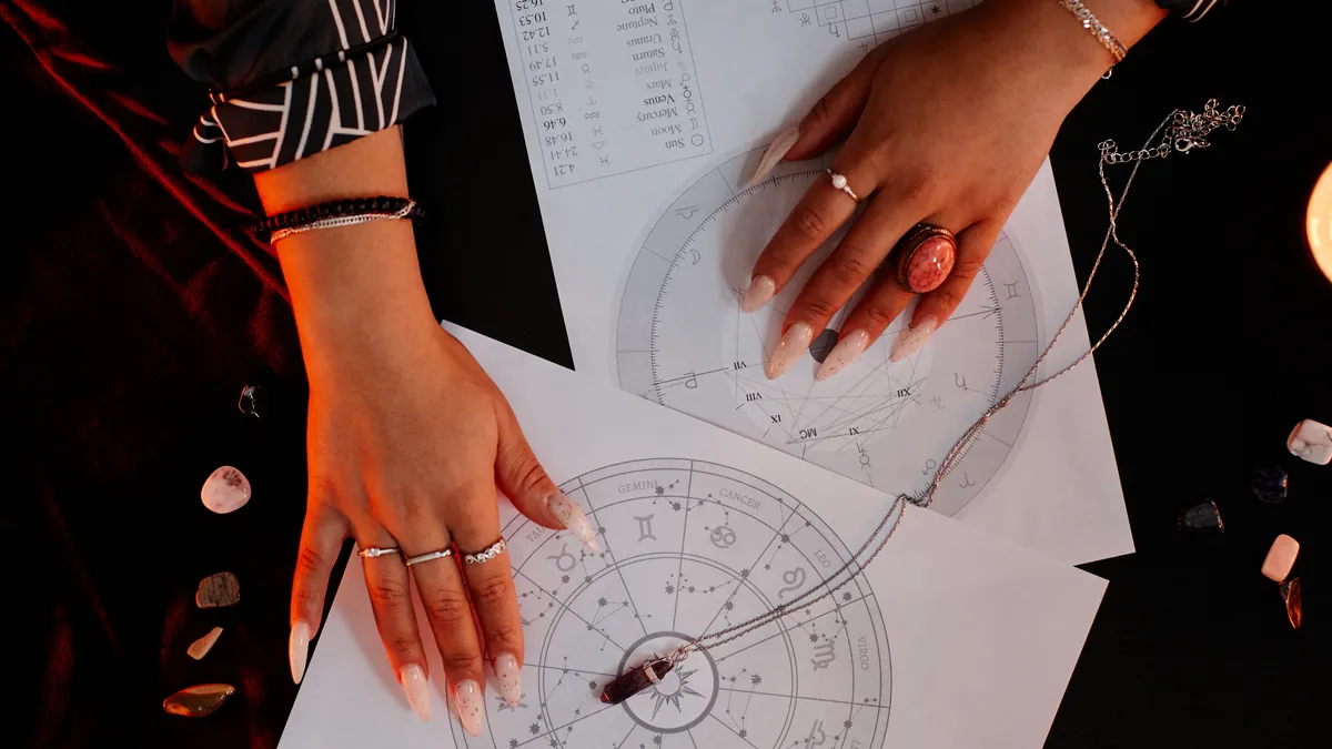 will she come back: hands reading an astrology birth chart illustration